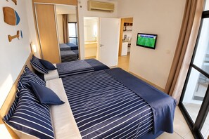 A hotel room with a bed, a television, and a view of the outside. - Clube XV (Santos)