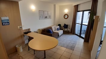 Uma sala de estar moderna com uma mesa redonda, um sofá e uma janela grande.