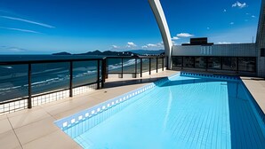 A modern rooftop pool with a clear view of the ocean and distant mountains. - Clube XV (Santos)