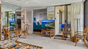 A living room with a television, wicker furniture, and a view of the ocean. - Oceanfront Condo Near Napili Bay 1br - Unit A17 1 Bedroom Condo (Lahaina)