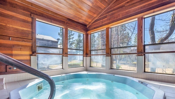 A hot tub in a room with wooden walls and large windows. - Tahoe City - Lake Forest Condo 3 Bedroom Condo (Tahoe City)