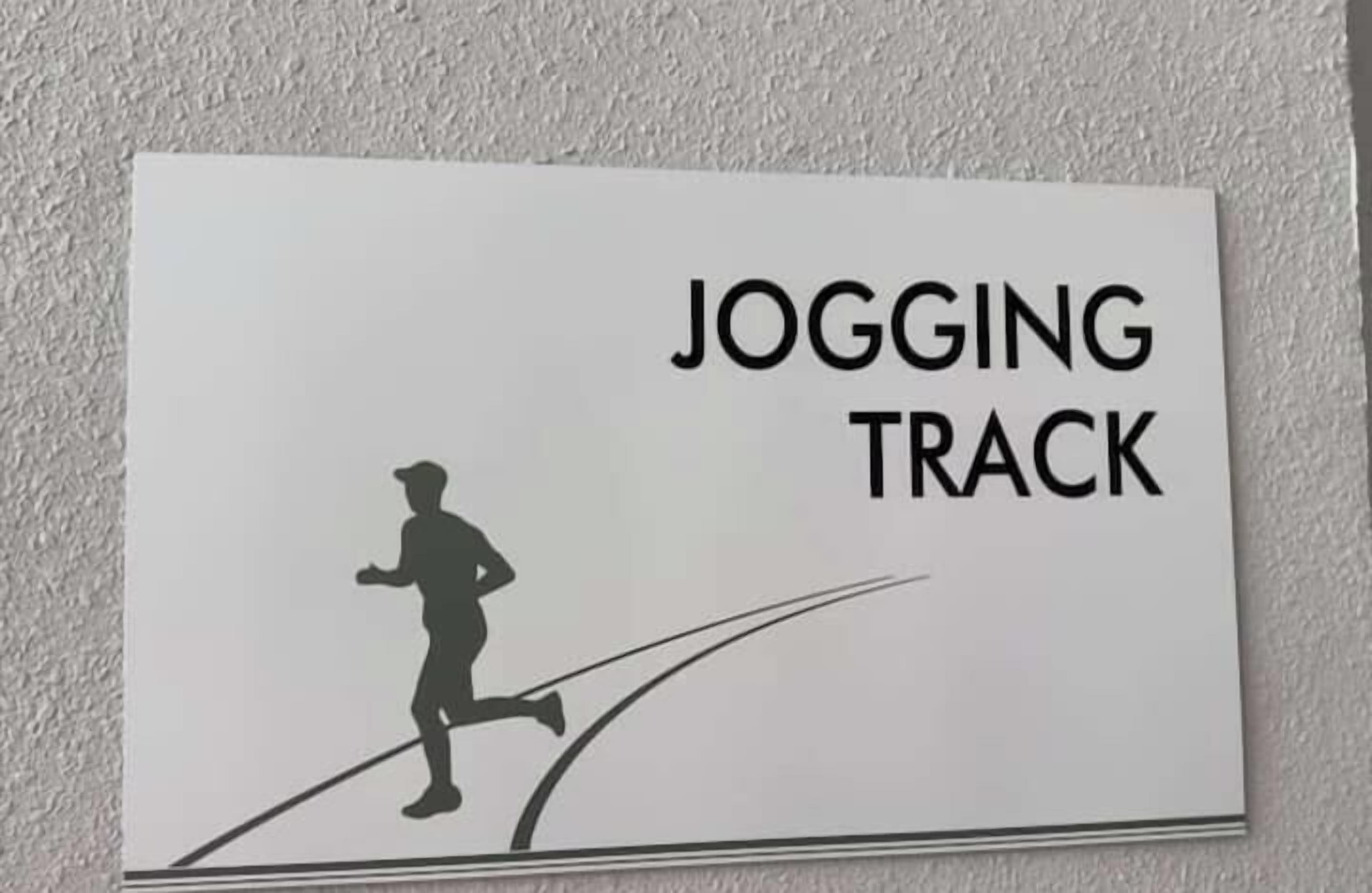 Un letrero que dice 'JOGGING TRACK' con la silueta de una persona corriendo.