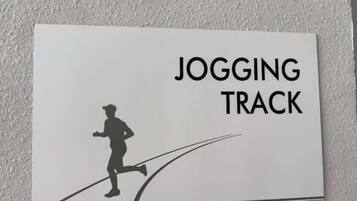 Un letrero que dice 'JOGGING TRACK' con la silueta de una persona corriendo.