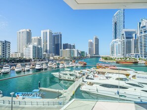 A marina with boats, a city skyline, and modern buildings. - Lavish 2BR with Balcony-Full Marina View (Dubai)
