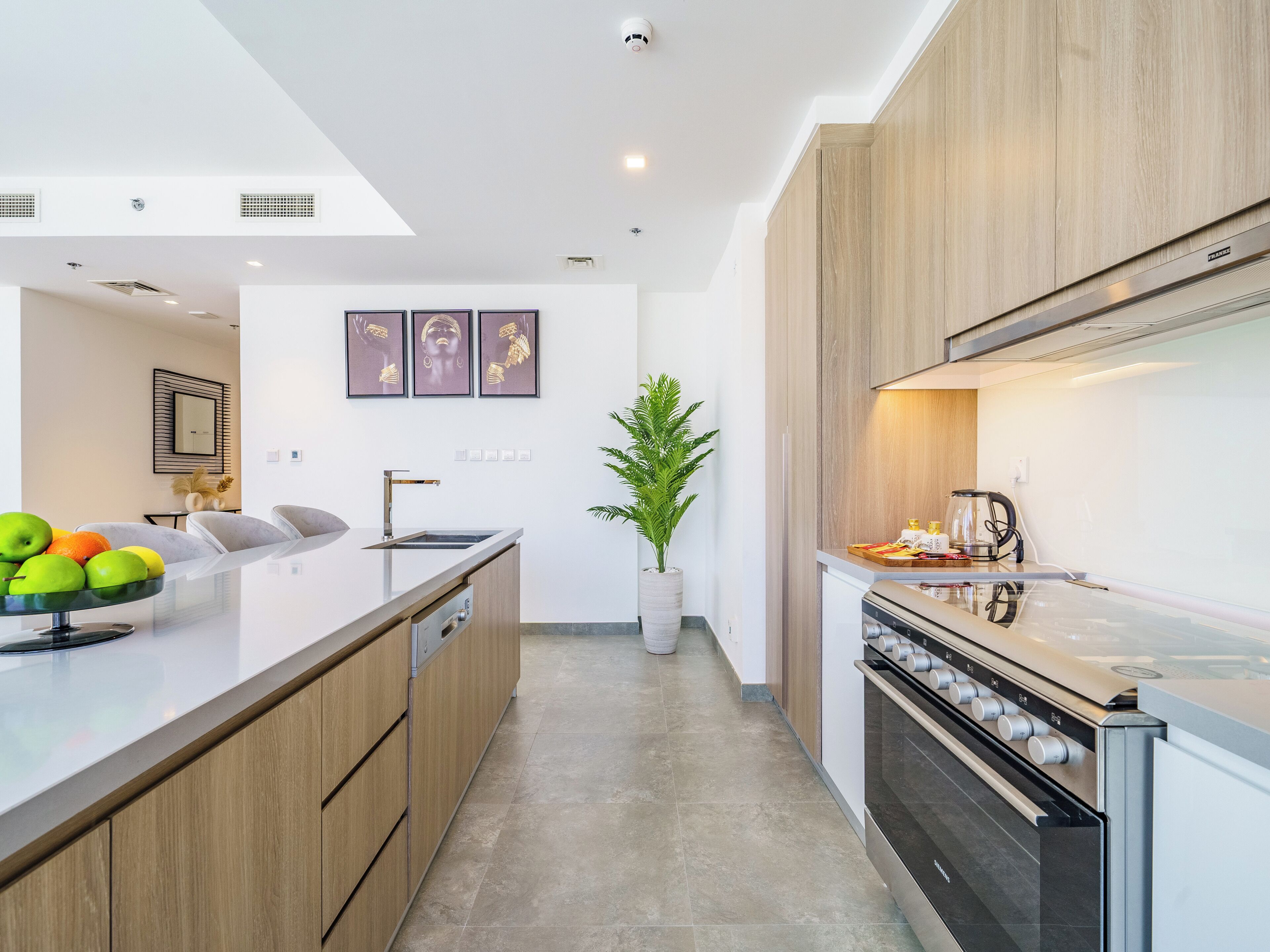 Una cocina moderna con una isla central, electrodomésticos de acero inoxidable y armarios de madera.