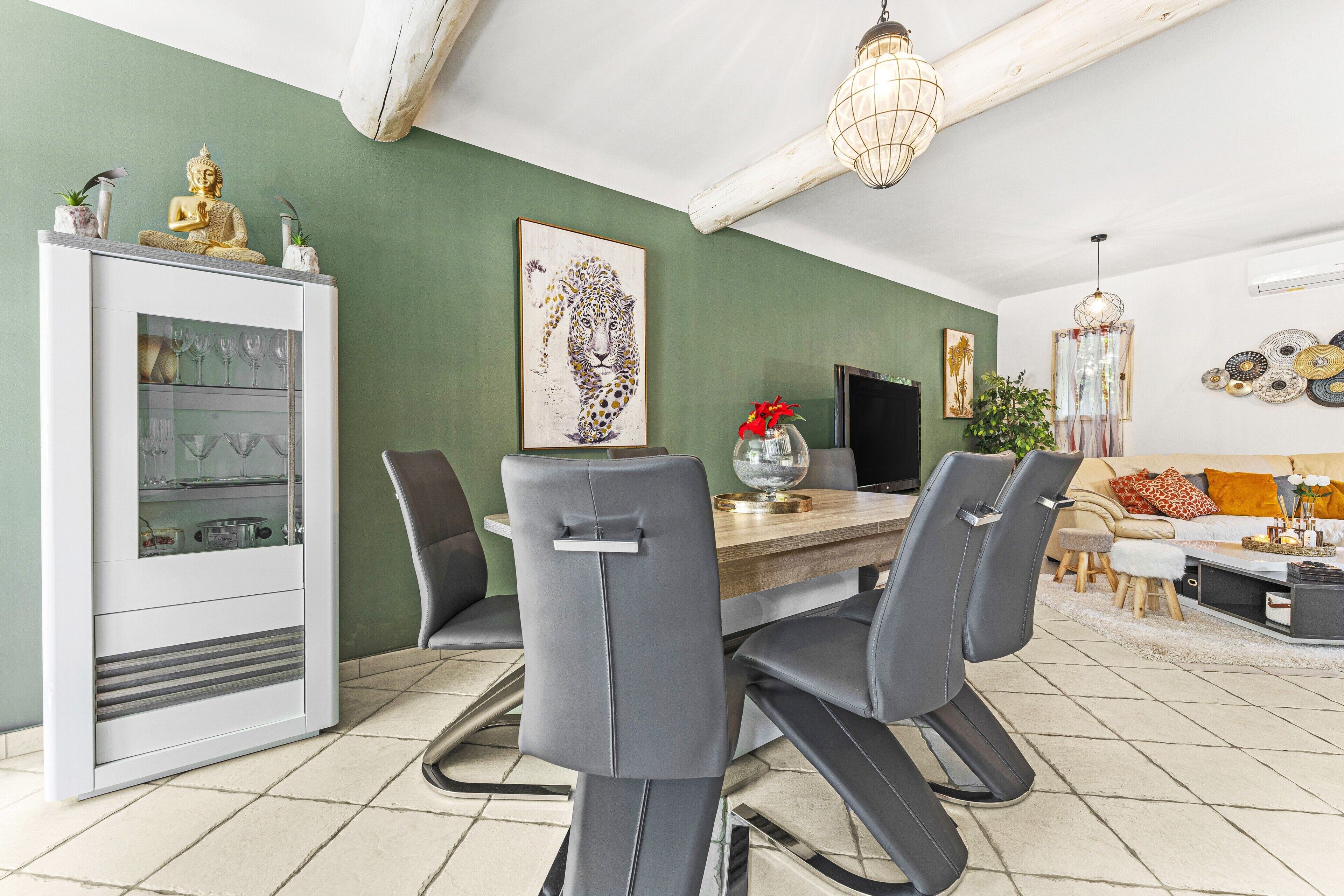A dining area with a table, chairs, and a Buddha statue.