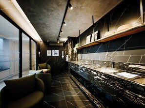A modern interior with a marble countertop, seating area, and a view through large windows. - 50m from Cabo Branco beach • High-end apartment (João Pessoa)