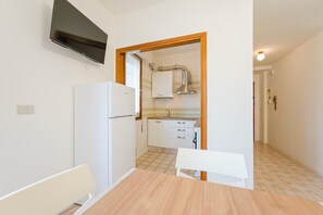 Eine kleine Küche mit Kühlschrank, Spüle und Fenster.