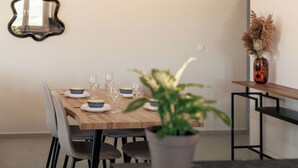 A dining table set with plates, glasses, and a potted plant. - Etherio Naxos Ouranos Charming 2-bedroom apartment with AC in beautiful Naxos (Cyclades)