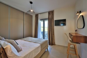 Ein Schlafzimmer mit Bett, Schreibtisch, Stuhl, Fernseher und einer Schiebetür.