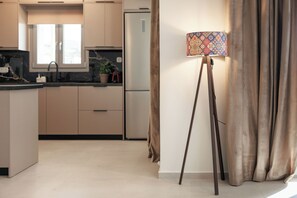 Eine moderne Küche mit einer zentralen Kochinsel, einem Kühlschrank und einem Fenster.