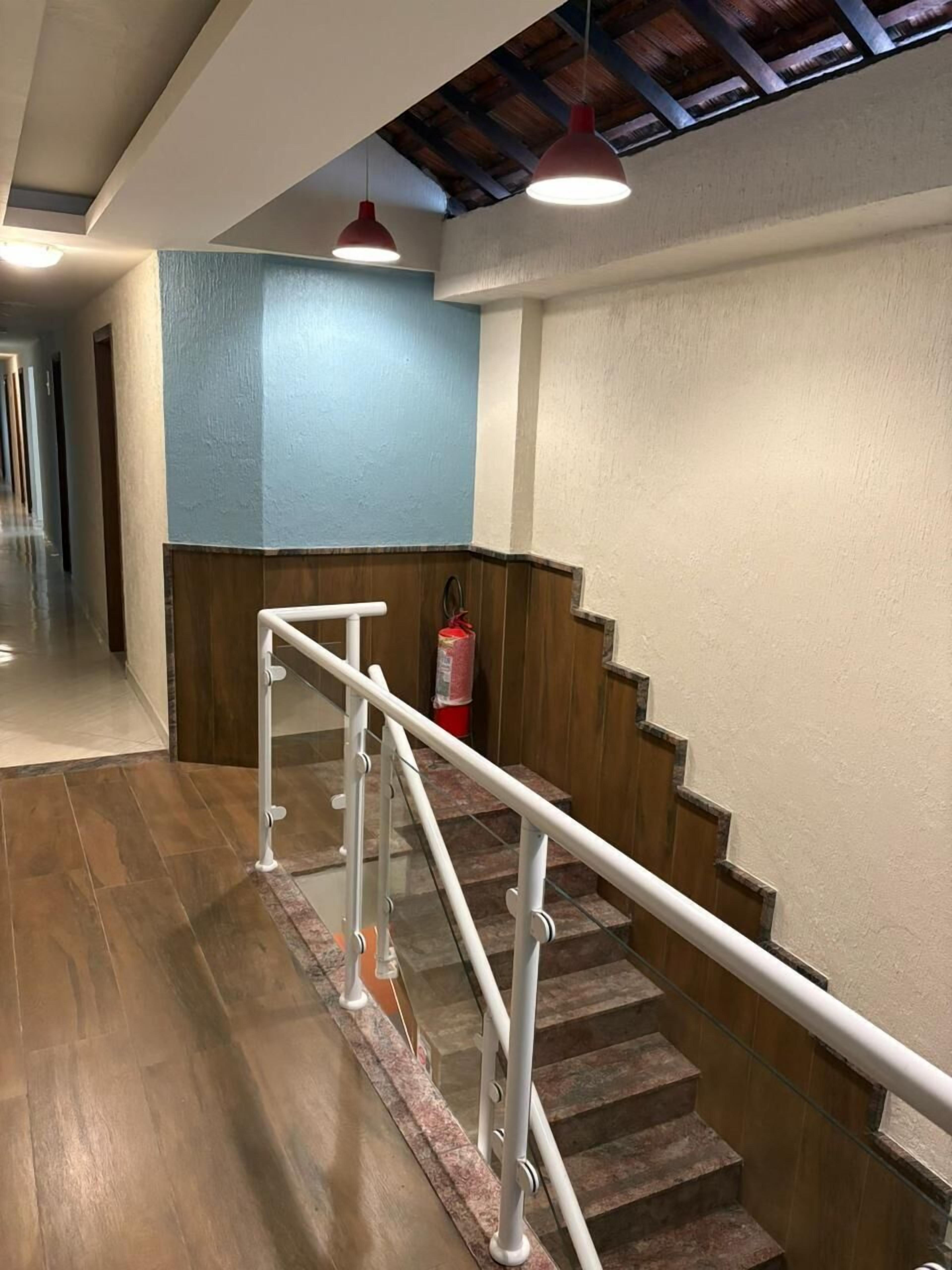 A staircase with white railings, wooden steps, and a blue wall.