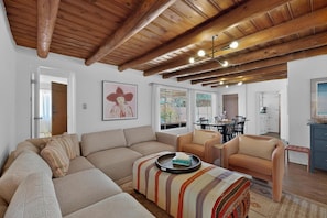 A living room with a sofa, armchairs, a coffee table, and a dining area with a table and chairs. - Old Charm Adobe Home, 3bd/2ba, Grill, Firepit (Albuquerque)