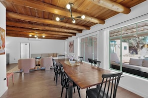 A spacious dining area with a wooden ceiling, large windows, and a view of the outside. - Old Charm Adobe Home, 3bd/2ba, Grill, Firepit (Albuquerque)