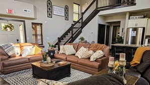 Ein Wohnzimmer mit einem braunen Sofa, einem Couchtisch und einer Treppe.