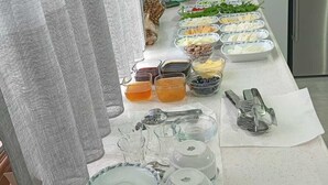 A buffet setup with various food items, serving utensils, and containers. - Koçi Hotel (Pazar)