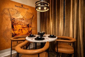 A restaurant interior with a round table, four chairs, a wall mural, and a hanging light fixture. - Huge DT 4BR Party House! 12 Beds! Private Hot Tub! (Nashville)