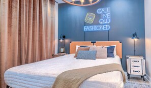 A bedroom with a bed, bedside tables, a neon sign, and curtains. - Huge DT 4BR Party House! 12 Beds! Private Hot Tub! (Nashville)