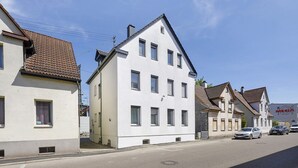 Une vue de rue avec des bâtiments, un ciel dégagé et des voitures garées.