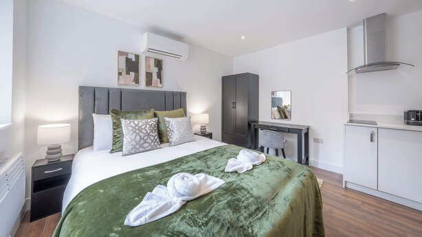 Une chambre d’hôtel équipée d’un lit, d’un bureau, d’une armoire et d’un appareil de climatisation.
