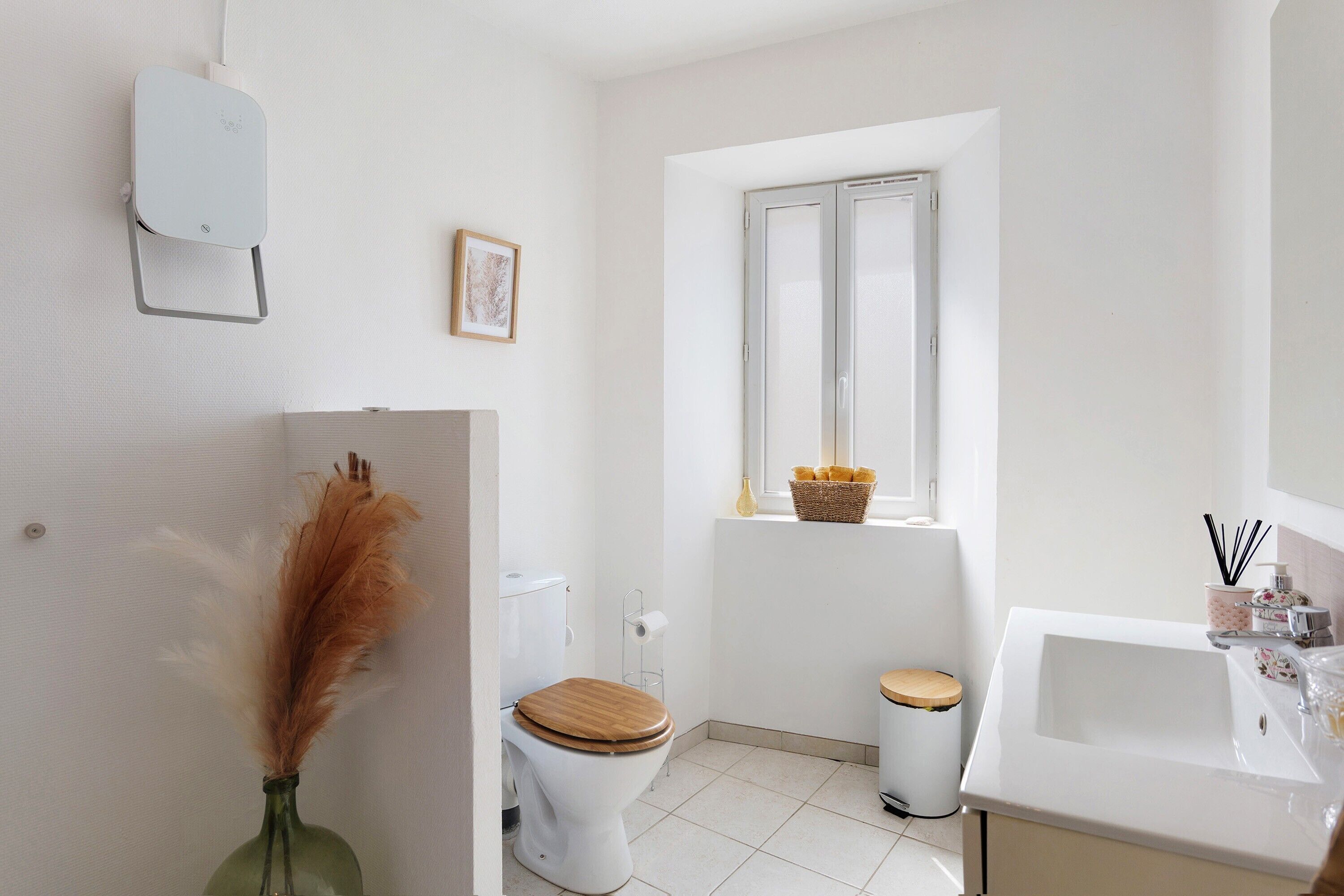Een moderne badkamer met toilet, bidet, wastafel en raam.