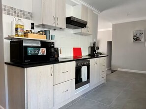 Eine moderne Küche mit Mikrowelle, Backofen und Schränken.