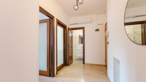 A hallway with wooden doors, a mirror, and an air conditioning unit. - Gaia's Flat - 15 min from Venice (Mestre)