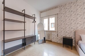 Un dormitorio con cama, cómoda, espejo y radiador.