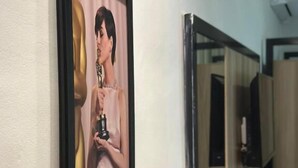 A framed photograph on a wall, a wooden table, and a mirror. - Hotel Oscar Gold Janaúba (Janaúba)