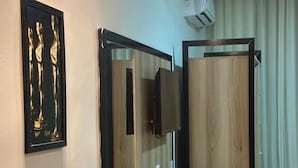 A hotel room with a wooden desk, a chair, a TV mounted on the wall, and a window with curtains. - Hotel Oscar Gold Janaúba (Janaúba)