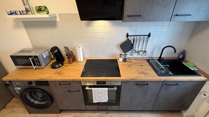 A compact kitchen with a microwave, coffee maker, and a dish rack. - GNA02.01 - Apartment with 5 beds, modern kitchen, balcony & parking space (Lüdenscheid)