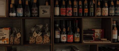 A well-organized shelf with various food items, books, and bottles.