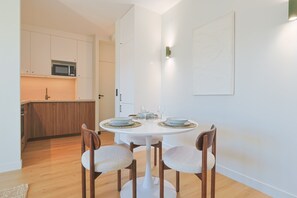 A dining area with a round table, four chairs, and a kitchen in the background. - 325 L Alba in Cannes (Cannes)