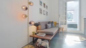 A modern living room with a sofa, a coffee table, a floor lamp, and wall art. - 221 Le Bella in Cannes (Cannes)