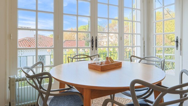 A round table with chairs, a basket, and a view through large windows. - 221 Le Bella in Cannes (Cannes)