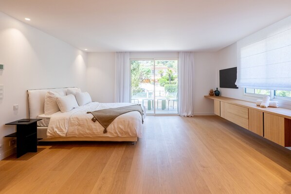 A modern bedroom with a bed, a TV, and a view of the outdoors. - 002 Villa Camille in Cannes (Cannes)