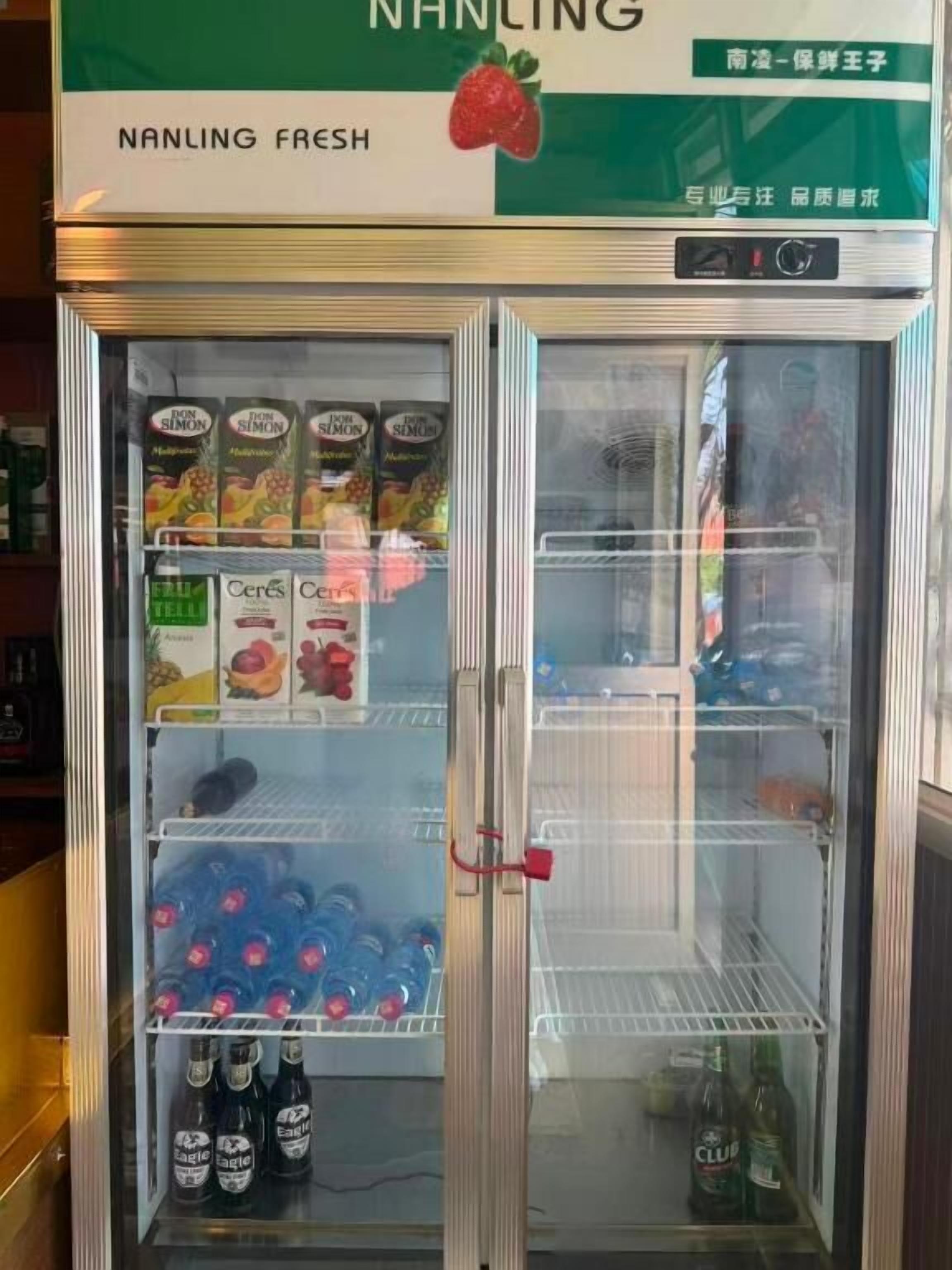A refrigerated display case with various beverages and snacks, including a section labeled 'NANLING FRESH' and another with 'DON SIMON' fruit juices.
