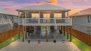 A two-story house with a balcony, a covered patio, and a fenced backyard. - Beach House - Coastal Dreaming (Port St. Joe)