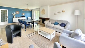 Ein modernes Wohnzimmer mit Essbereich, einer Couch und einem Kamin.