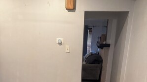 A room with a patterned rug, a wooden cabinet, and a doorway leading to another room. - Tranquil 3-bedroom apartment with AC in Pittsburgh Oakland area. (Pittsburgh)