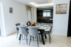Ein Essbereich mit Tisch für vier Personen, im Hintergrund eine Küche und ein Buddha-Gemälde an der Wand.