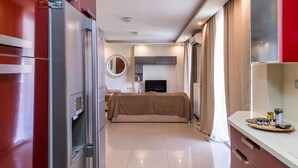 Camera d'albergo moderna con letto, televisore, minibar e bagno con doccia e WC.