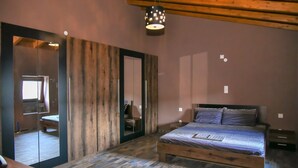 A bedroom with a wooden bed, a large mirror, and a wooden ceiling. - Villa 4 season: Poolside Paradise in Crete (Agia Varvara)