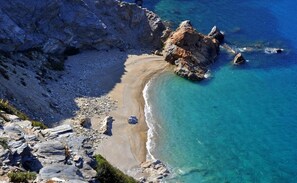 A coastal landscape with rocky terrain, clear blue waters, and a sandy beach. - Villa 4 season: Poolside Paradise in Crete (Agia Varvara)