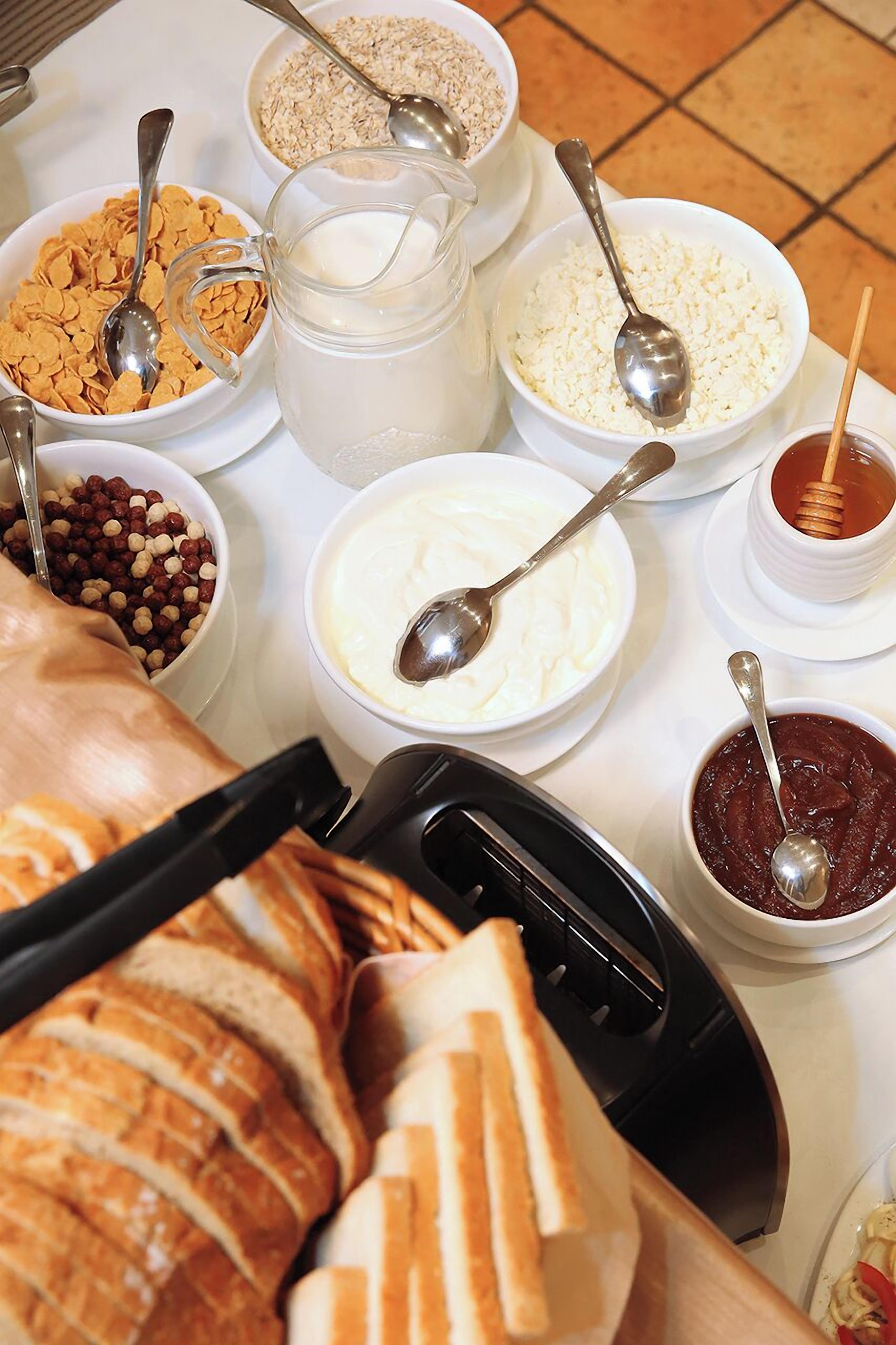 A breakfast buffet with various food items and utensils.