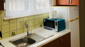 Eine Küche mit Spüle, Mikrowelle und Kühlschrank.