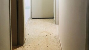 Ein Flur mit einer Tür, einer Pendelleuchte und einem an der Wand befestigten Gerät.
