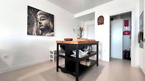 Eine moderne Küche mit Holzarbeitsplatte, schwarzen Regalen und einem großen Wandbild.