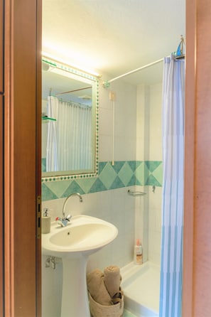 A bathroom with a sink, mirror, shower, and a towel rack. - SKY APARTMENT SEA VIEW (Mades)