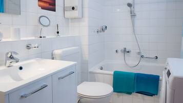 Un baño moderno con inodoro, lavabo y ducha.
